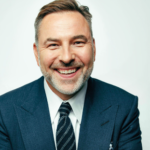 David Walliams in a reflective pose, symbolizing his satirical style and scholarly influence in literature and entertainment.